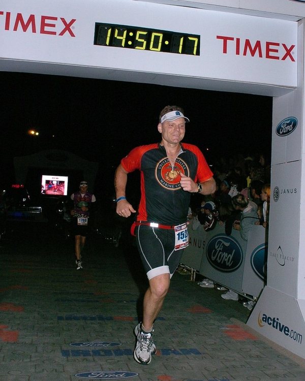 Will Power crossing the Ironman Lake Placid finish line in a Marine Corps jersey