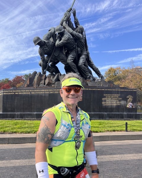 Will Power with his finisher medal at the Marine Corps War Memorial after the 2025 Marine Corps Marathon